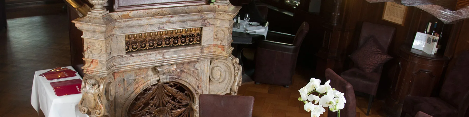 Der Kamin mit dem Wappen der Familie von den Driesch, davor gedeckte Tische