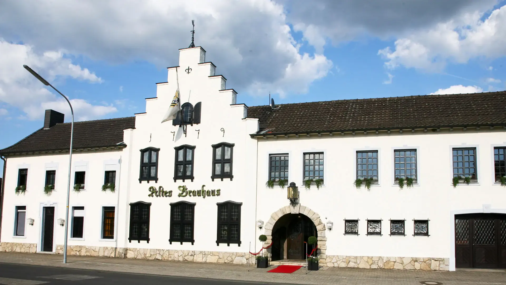 Das Alte Brauhaus in Unterbruch: weißes Haus mit Stufengiebel und der Jahreszahl 1779